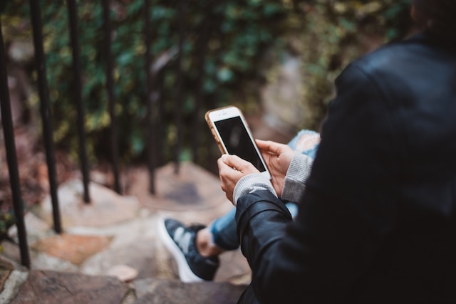 Picture of person with cell phone, photo by Chad Madden, via Unsplash