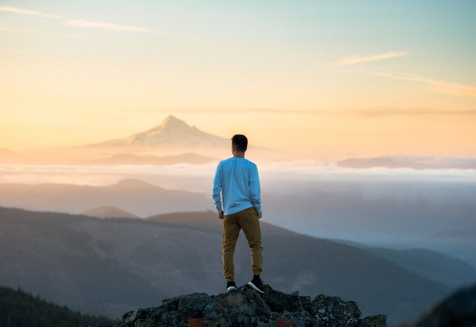 Picture of a person at the top of a mountain at Grouse Vista Trailhead, photo by Tim Bogdanov, via Unsplash
